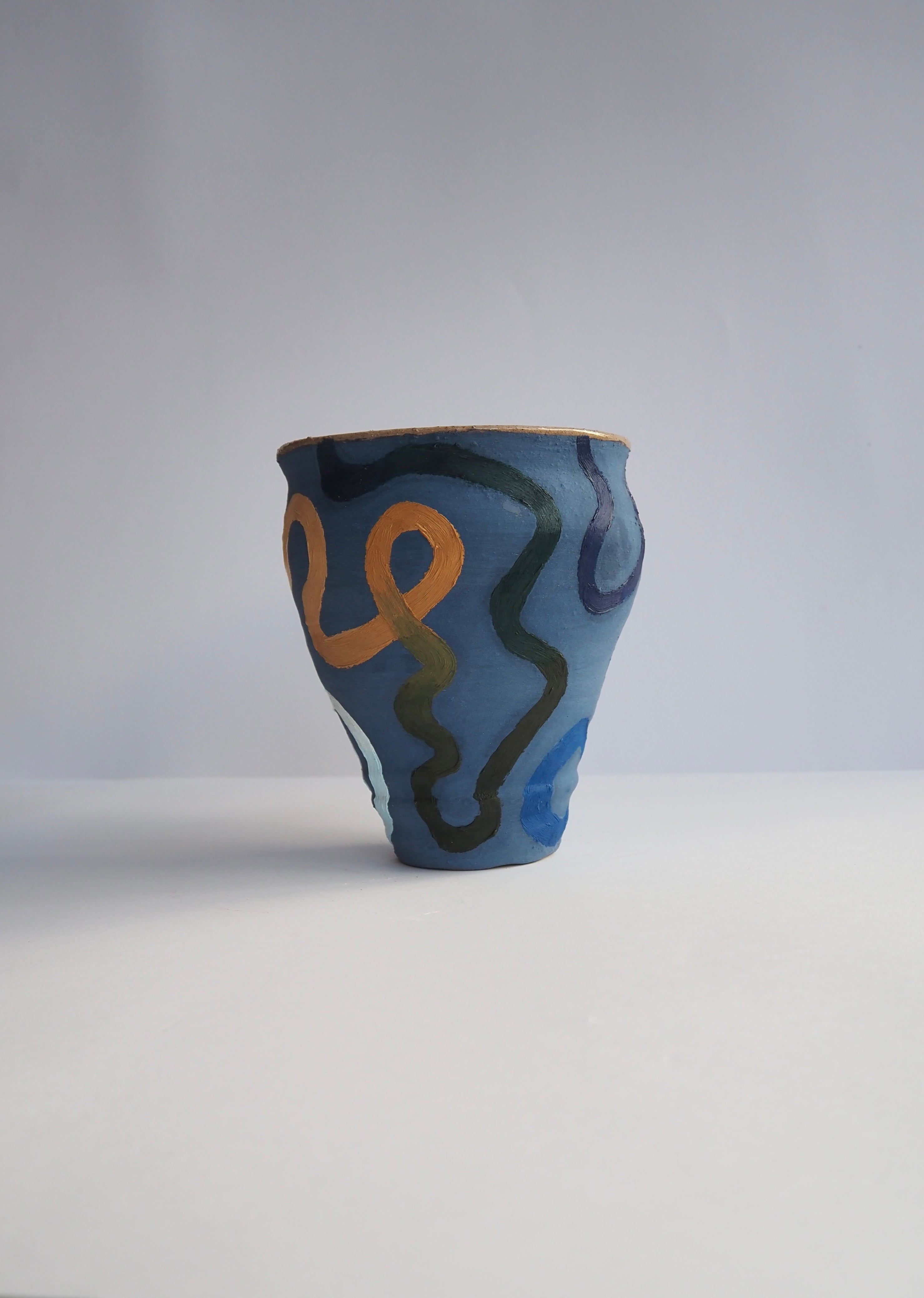 Ceramic cup with abstract patterns on a blue background