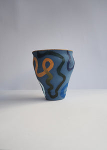 Ceramic cup with abstract patterns on a blue background
